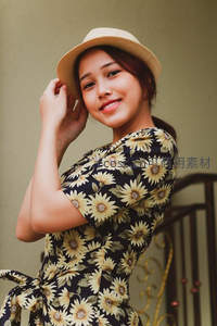 向日葵裙少女轻触草帽微笑