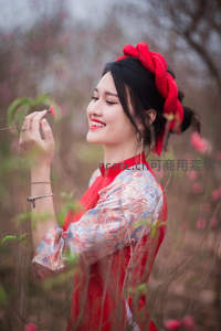 红衣女子赏花微笑，传统发饰映春色