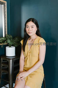 黄裙女子深蓝墙前优雅坐姿