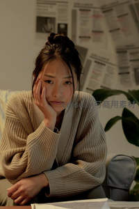 沉思少女倚桌凝望，温暖毛衣包裹思绪