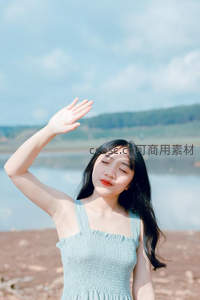 闭眼享受阳光的湖边女孩