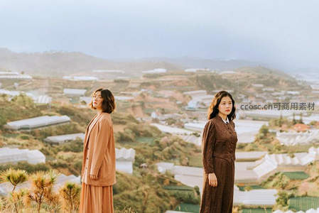 山丘之上，两位女子眺望远方村落