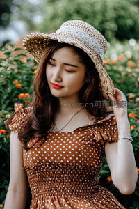 草帽少女花园中，波点裙装显甜美