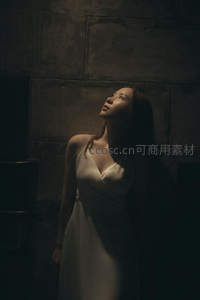 暗调光影中白衣女子仰望