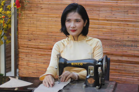 传统服饰女子专注操作老式缝纫机
