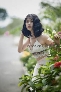 路边花丛中少女手抚秀发回眸