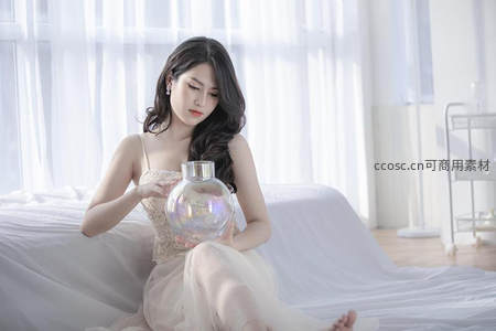 卧室中女子手持水晶球凝神静思