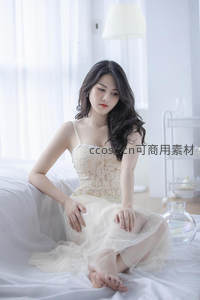 白衣女子静坐床边凝视远方