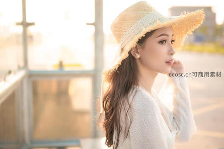 草帽少女侧颜沐浴阳光，白色针织衫显清新优雅