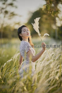 芦苇丛中闭目享受阳光的少女