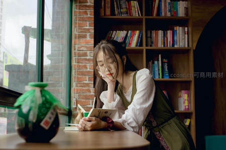 咖啡馆窗边女孩戴眼镜读书，砖墙书架营造文艺氛围