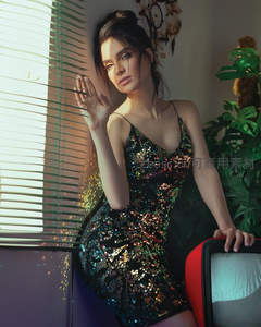 闪亮吊带裙女子倚窗光影迷人