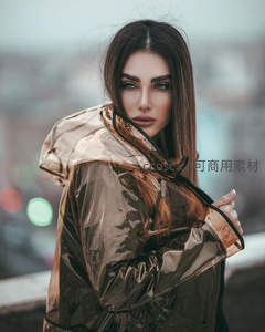 棕金色雨衣女子回眸凝视镜头瞬间
