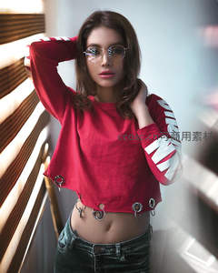 红衣少女倚窗享受午后阳光