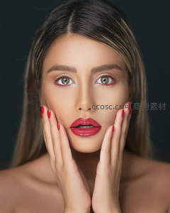 双手轻托脸颊，红唇美甲尽显柔美风情