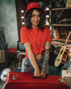 微笑女子手扶红箱，复古房间中的活力瞬间