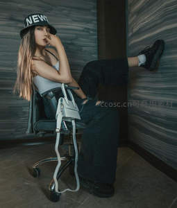 潮流女孩戴帽坐椅摆酷姿势
