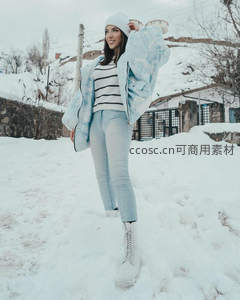 雪地微笑少女，条纹毛衣配浅蓝羽绒服