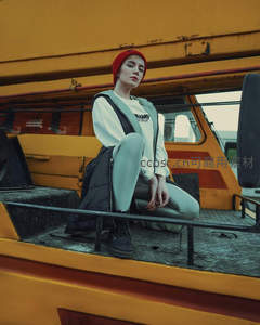 红帽少女坐于黄色工程车前