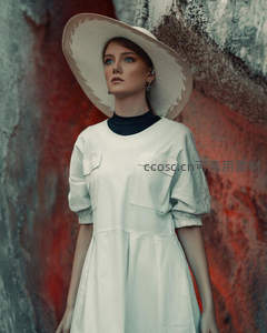 红岩背景中沉思的白衣女子