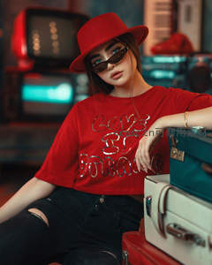 红衣女子戴墨镜倚行李箱摆造型