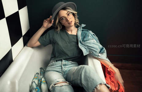 浴缸中的时尚女孩与啤酒瓶