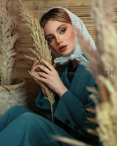 蓝西装女子手持干草温柔凝视