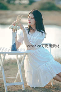 白衣女子湖畔品花香，宁静悠然