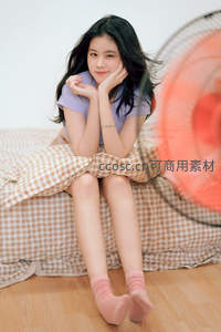 风扇微风中俏皮少女，格纹床畔笑容甜美