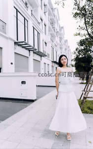 白衣女子漫步现代街区，清新优雅