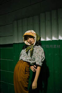 光影下的复古美人，头巾与绿墙相映成趣