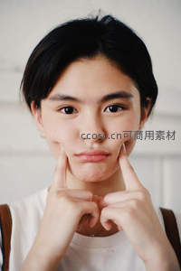 少女俏皮捏脸，纯真笑容直击人心