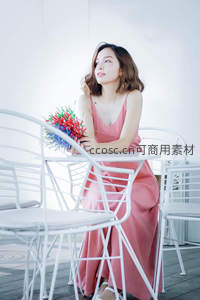 粉裙女子咖啡馆静坐，手捧花束望远方