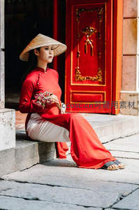 石阶红门前，女子静坐捧花，斗笠遮阳姿态闲适