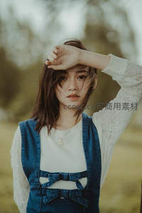 户外微风中遮阳的少女