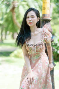 花裙少女倚柱绿荫公园中