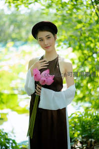 持莲女子微笑凝视镜头绿意间