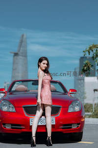 红车前的高挑美女回眸凝视