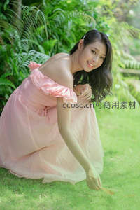 绿意盎然中粉裙少女俯身拾叶