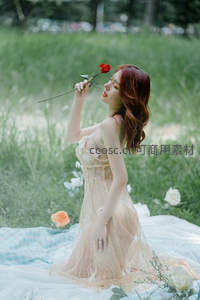红发佳人跪坐野花丛中轻嗅玫瑰芬芳