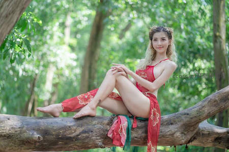 红衣女子坐树干双腿交叠