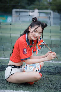 红衣少女抱球微笑持英旗