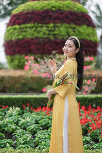 黄袍女子花丛回眸，温婉动人