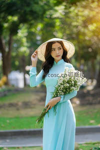 蓝衣女子手捧白花戴斗笠