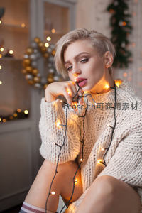 暖光灯串环绕的毛衣少女