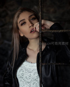 铁栅栏后沉思的皮衣美人