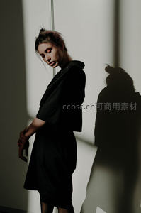 光影交错中黑衣女子侧身沉思剪影