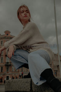 都市街头时尚女郎坐在石阶凝望远方