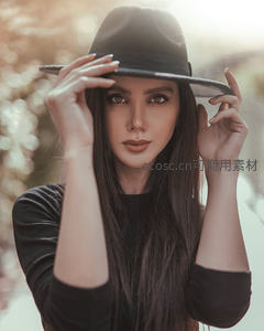 戴帽女子双手轻扶帽檐直视镜头特写