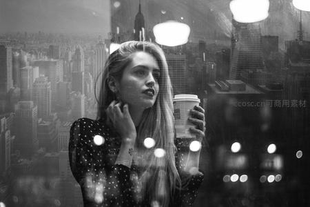 都市窗前沉思的女子，手握咖啡凝望远方